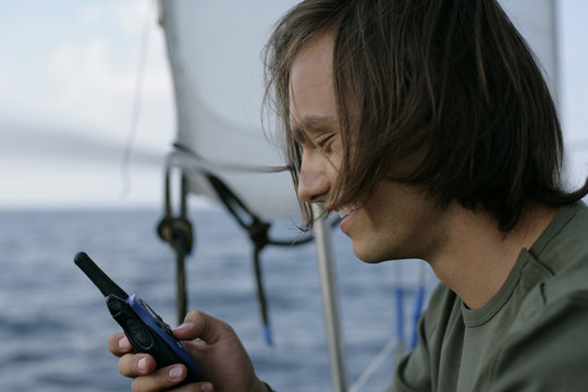 Man with a walkie-talkie on a sailboat