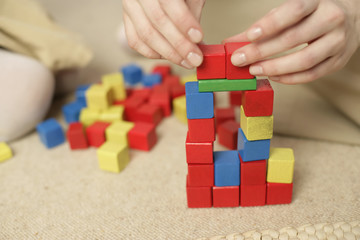 Woman stacking blocks, focus on hands