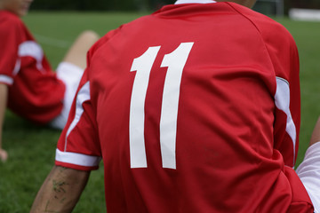 Soccer player wears number 11 sitting on grass