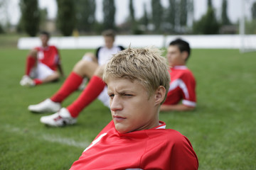 Soccer players sitting on grass