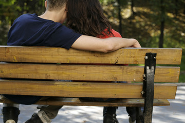 Fototapeta premium Teenage couple sitting on a bench
