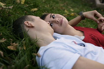 Teenage couple lying on grass