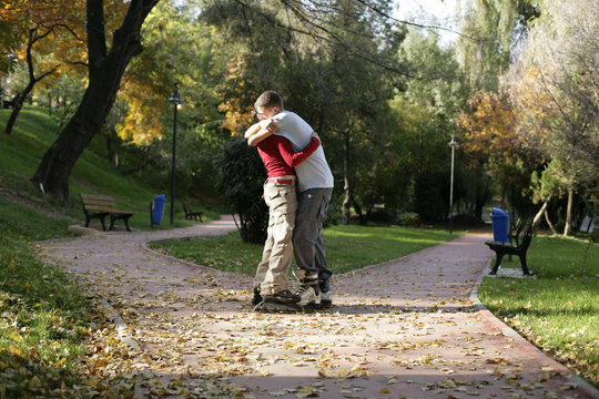 Teenage couple with inline skates embracing