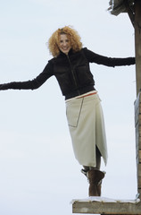 Young redhaired Woman balancing on the Terrace of a wooden Cottage - Fun - Leisure Time