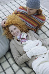 Young Woman with red Curls lying in the Lap of her Boyfriend - Relationship - Togetherness - Season