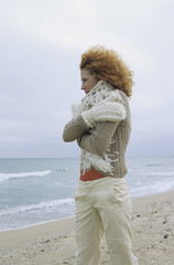Woman with a strawberry blonde curly Head strolling along the Beach - Lonliness - Season - Nature