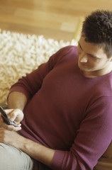Man typing something into his Mobile - Cell Phone - Living Room - Home