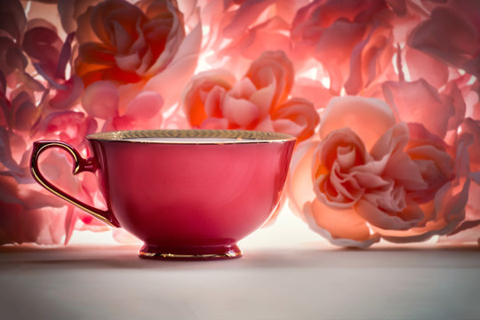 single red teacup on a pink floral background