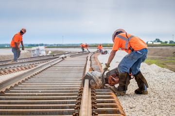 man working rail saw and railroad construction