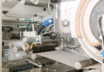 equipment and mechanism with a moving cloth tape on rollers closeup. in the production of moving fabric tape on network rollers