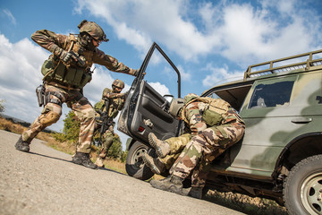 Squad of elite french paratroopers of 1st Marine Infantry Parachute Regiment RPIMA detaining terrorist in the car, low angle view