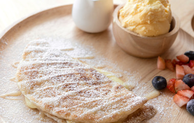 fresh dessert soft vanila roti with ice cream ,syrup ,strawberry and blueberry on plate in restaurant ,selective focus