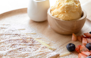 fresh dessert soft vanila roti with ice cream ,syrup ,strawberry and blueberry on plate in restaurant ,selective focus