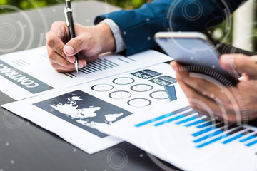 Handsome businessman wearing suit and using modern laptop outdoors and graph finance diagram.