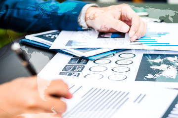 Handsome businessman wearing suit and using modern laptop outdoors and graph finance diagram.