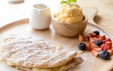 fresh dessert soft vanila roti with ice cream ,syrup ,strawberry and blueberry on plate in restaurant ,selective focus.