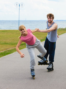 Woman encourage man to do rollerblading