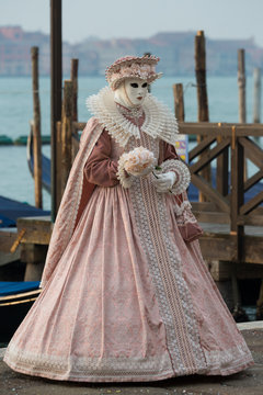 Donna mascherata da dama veneziana in rosa