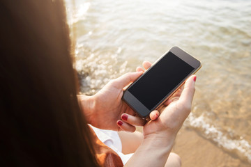 Woman using Smart Phone on summer Beach