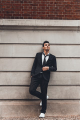 Young handsome male model walks around New York streets. Outdoor shot.