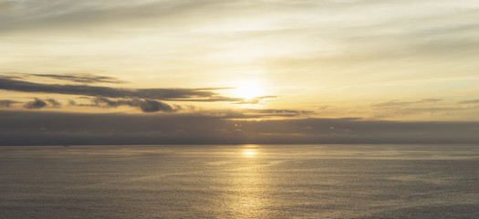 Clouds sky and sunlight gold sunset on horizon ocean. Background seascape dramatic atmosphere rays sunrise. Relax view waves water sea, mock up nature evening concept perspective sunrise