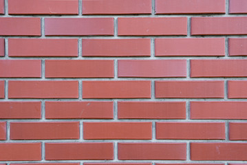 Brick wall of red brick with elements of concrete