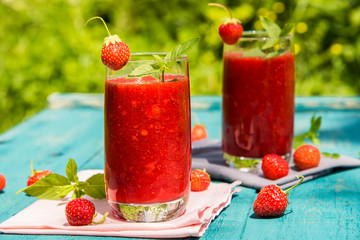 Strawberry smoothies on an old blue wooden surface