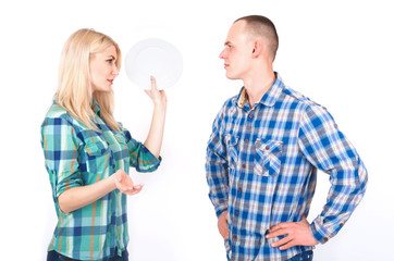 A man and a young woman with a plate in her hand quarrel in a studio.