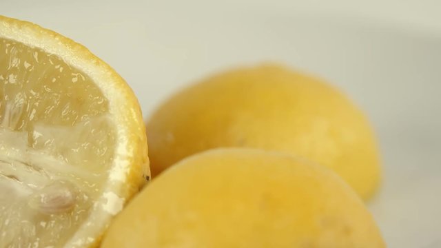 Sliced lemon falling on clean background