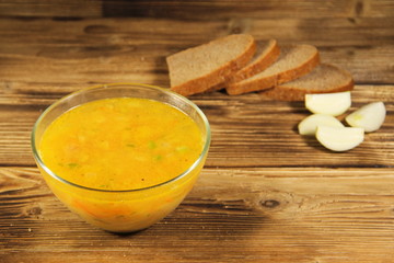 Fresh pea soup in glass bowl on wooden table