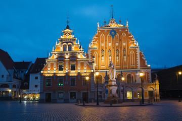 Obraz premium RIGA, LATVIA - 20 JUN 2016: City Hall Square with House of the Blackheads and Saint Peter church in Riga Old Town at night.