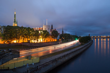 Fototapeta premium Night scene with traffic, old town and river bank in Riga, Latvia