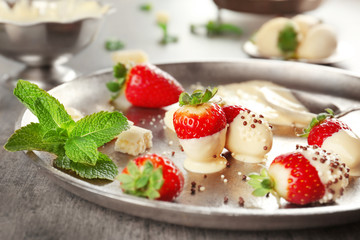 Delicious strawberries with white chocolate on silver tray