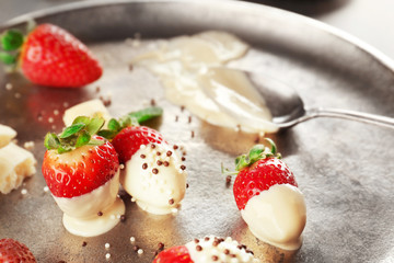 Delicious strawberries with white chocolate on silver tray