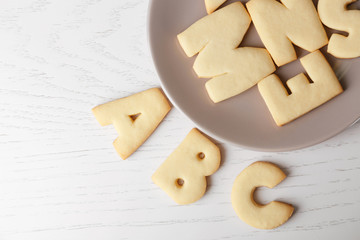 Plate with cookie alphabet on wooden  table