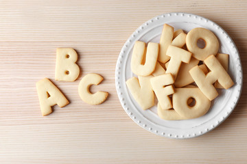 Plate with cookie alphabet on wooden  table