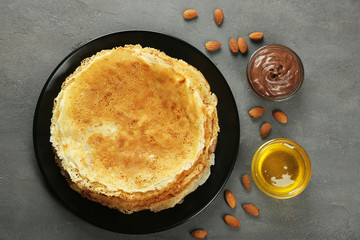 Plate with tasty pancakes on grey table