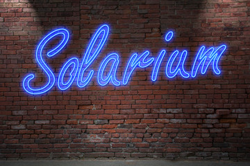 Leuchtreklame Solarium an Ziegelsteinmauer - obrazy, fototapety, plakaty