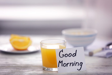 Glass of juice and note GOOD MORNING on kitchen table