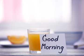 Glass of juice and note GOOD MORNING on kitchen table