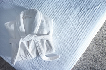 Folded spa bathrobe on bed