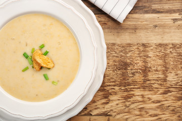 Delicious beer cheese soup with croutons on table