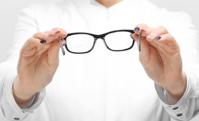 Mature female ophthalmologist with glasses on white background, closeup