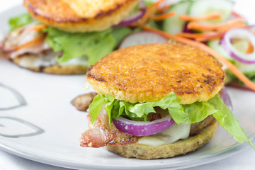 Grain free burger in fried egg bun with vegetables.