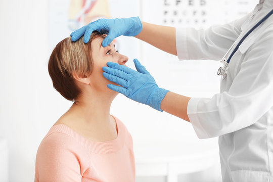 Ophthalmologist examining eyes of mature woman in clinic