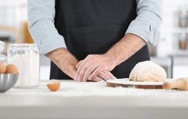 Obraz na płótnie Canvas Man preparing pasta on kitchen table