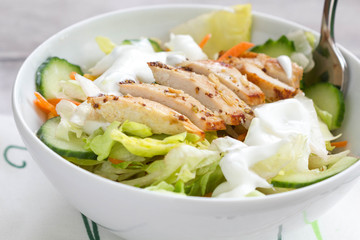   Healthy chicken salad with  fresh vegetables in a white bowl.