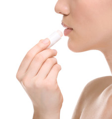 Woman applying hygienic lip balm on white background