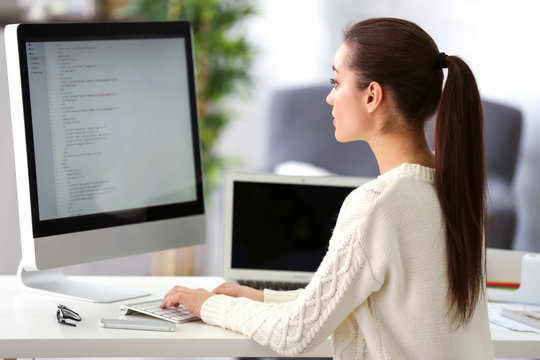 Young attractive programmer working at office