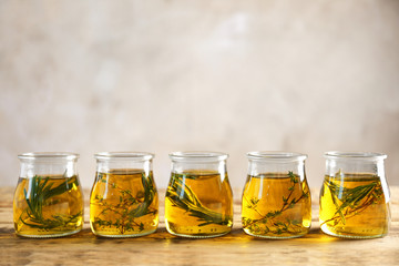 Row of jars with oil on wooden table